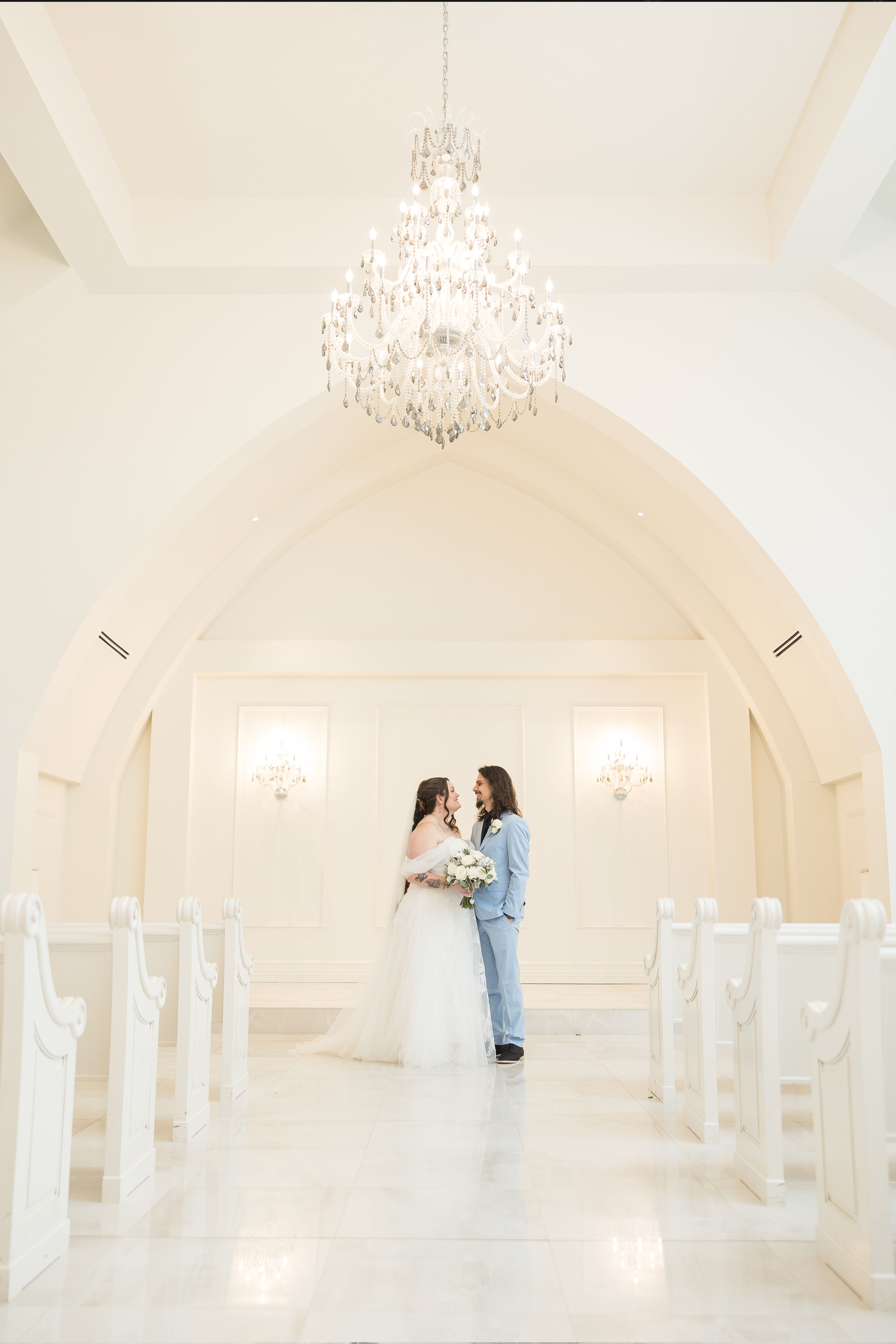 a bride and groom standing in the aria chapel