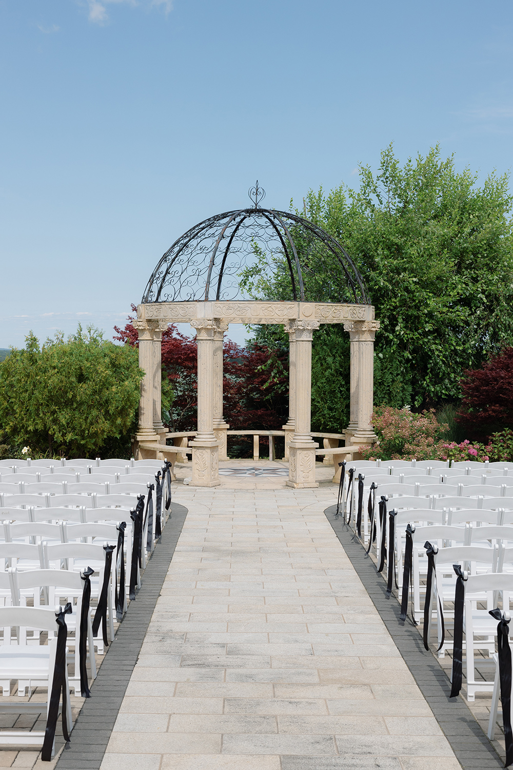 rows of chairs facing a gazebo outside