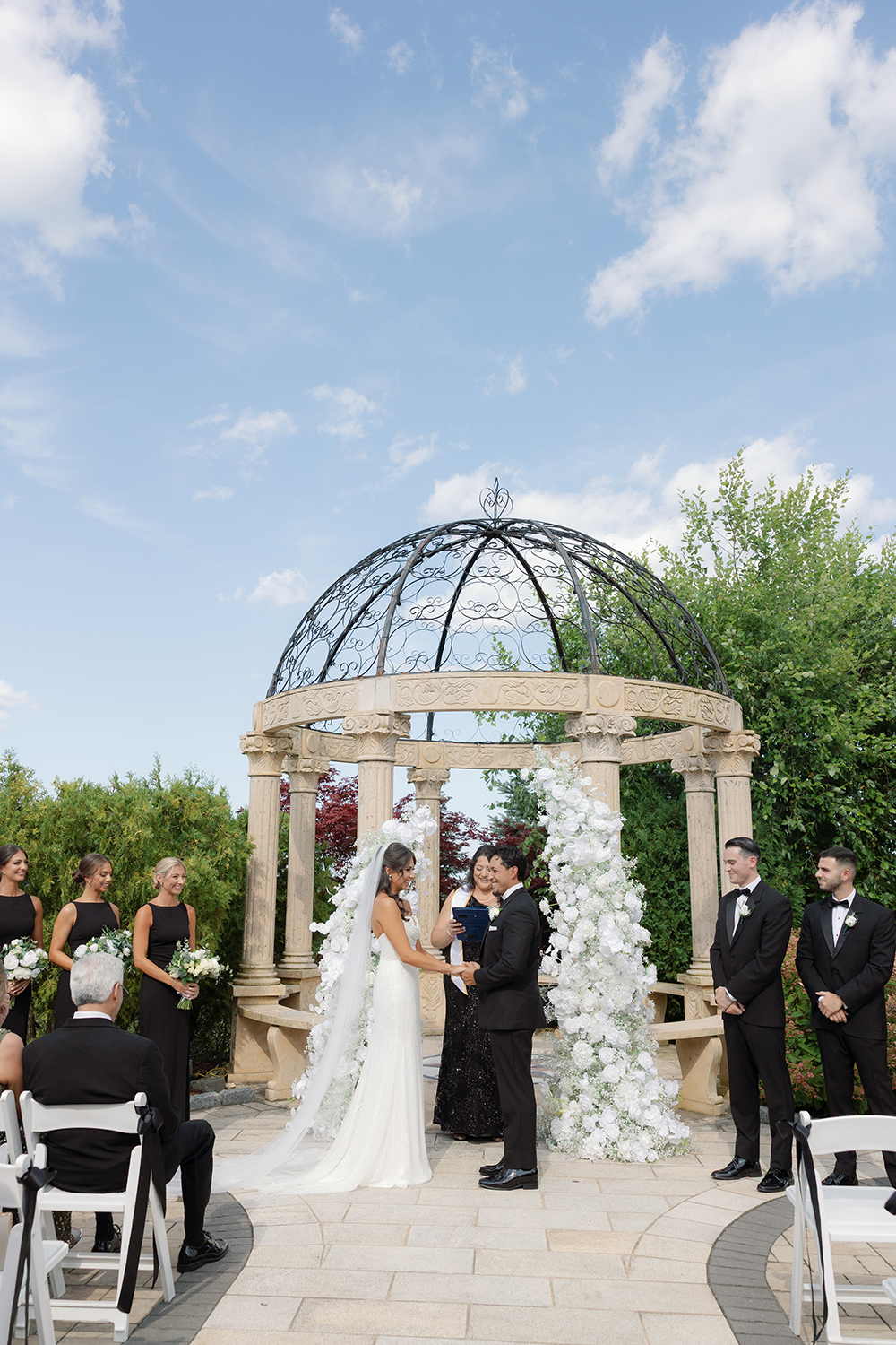 a bride and a groom exchanging vows outside the aria gazebo