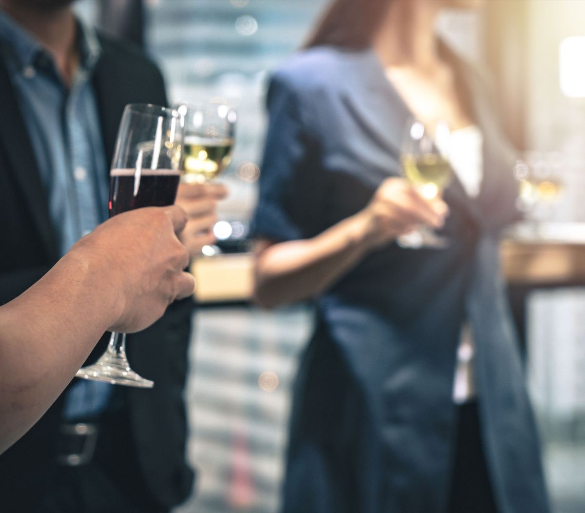 employees holding a glass of wine at a corporate event