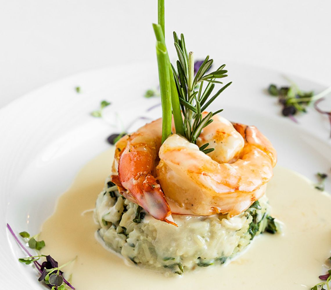 Elegantly plated course of shrimp and rice.