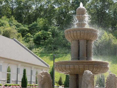 a water fountain outside with greenery in the distance