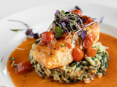 Salmon over wild rice with tomatoes and micro greens.