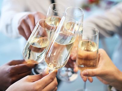 a group of hands clinking champagne flutes together