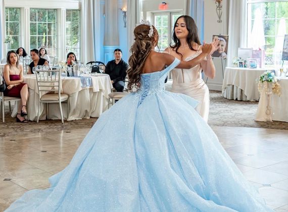 
Teen girl in a blue formal dress dancing in the Aria ballroom.
